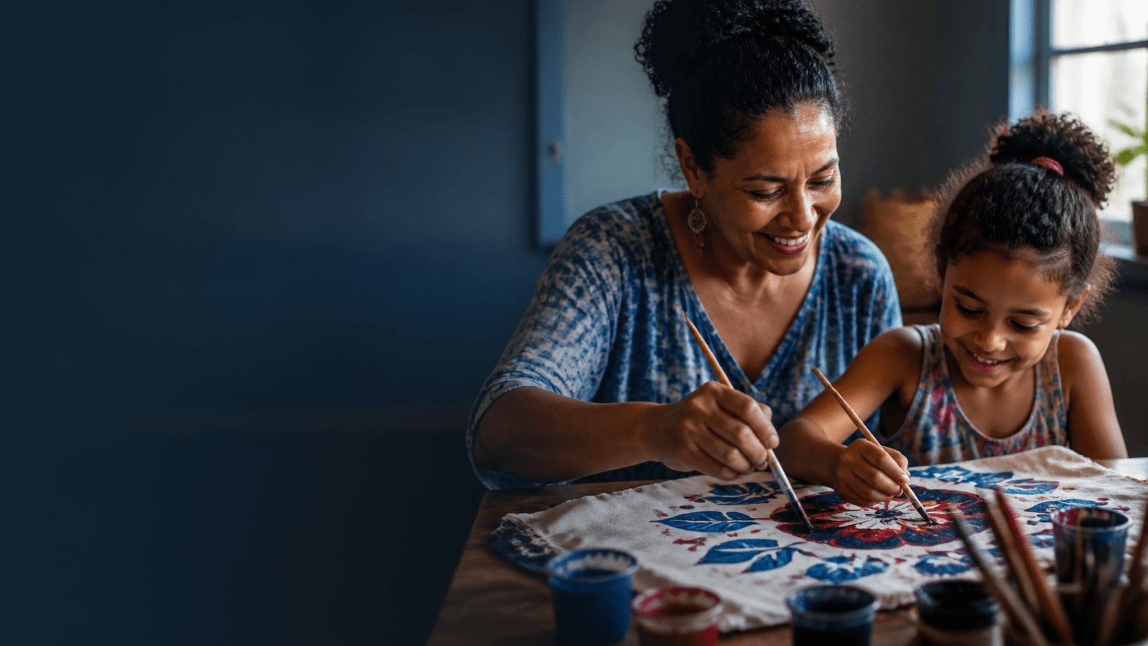 Adulto e criança pintando juntos em uma oficina da ACAI