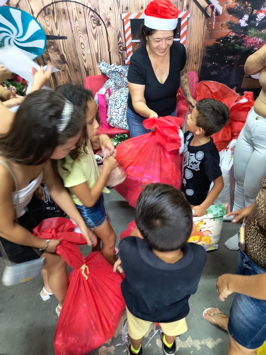 Crianças recebendo presentes durante uma ação de Natal da ACAI