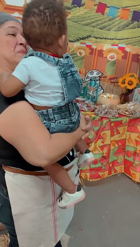Criança recebendo brinquedo durante encontro da ACAI — registro 021