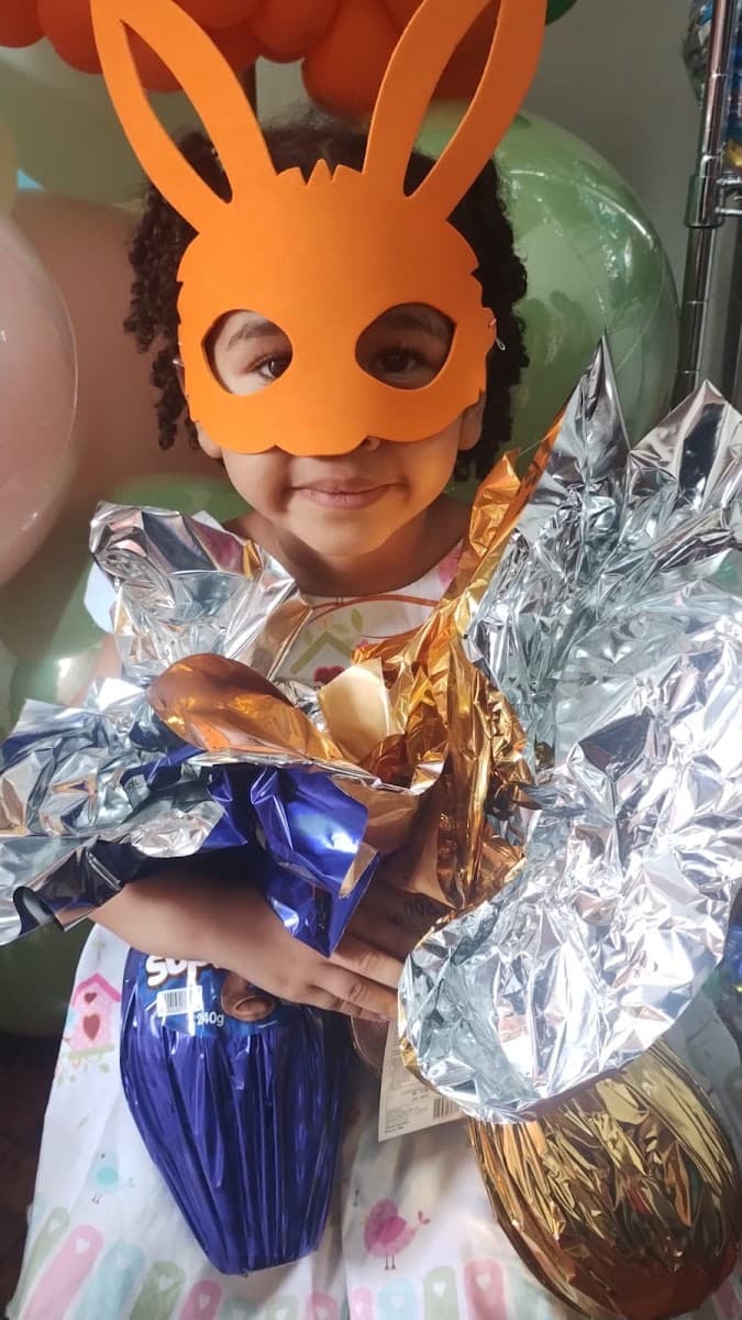 Criança sorrindo com brinquedo durante festa da ACAI — registro 076